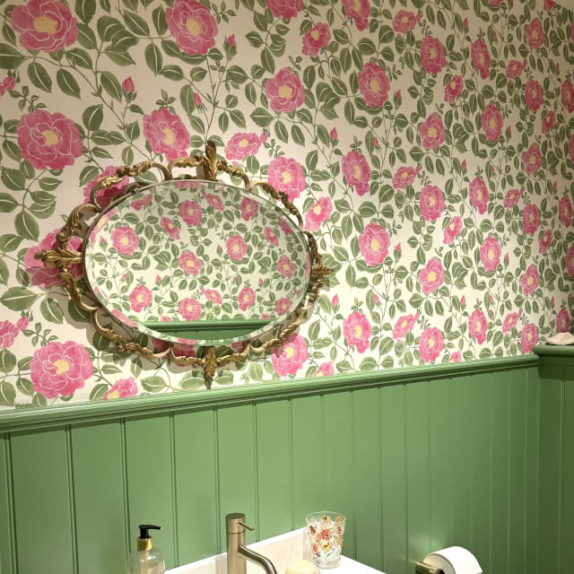 łazienka z zieloną boazerią angielską i tapetą w róże