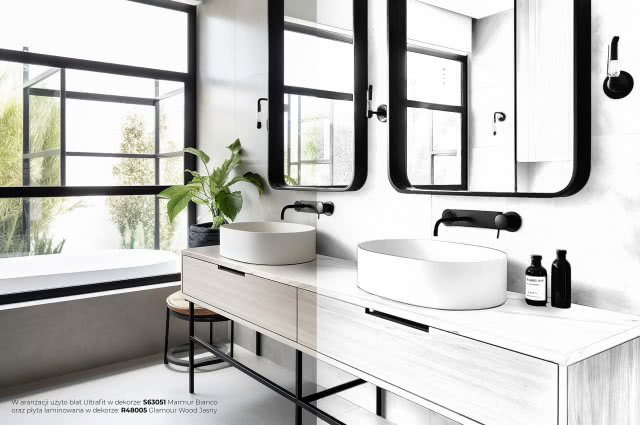 łazienka, dwie białe umywalki nablatowe, szafka podumywalkowa, dwa prostokątne lustra, kwiat w doniczce, duże okno, kinkiety