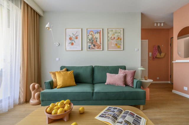 butelkowozielona kanapa w pastelowym salonie