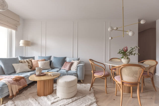 błękitna kanapa w salonie ze sztukaterią na ścianach