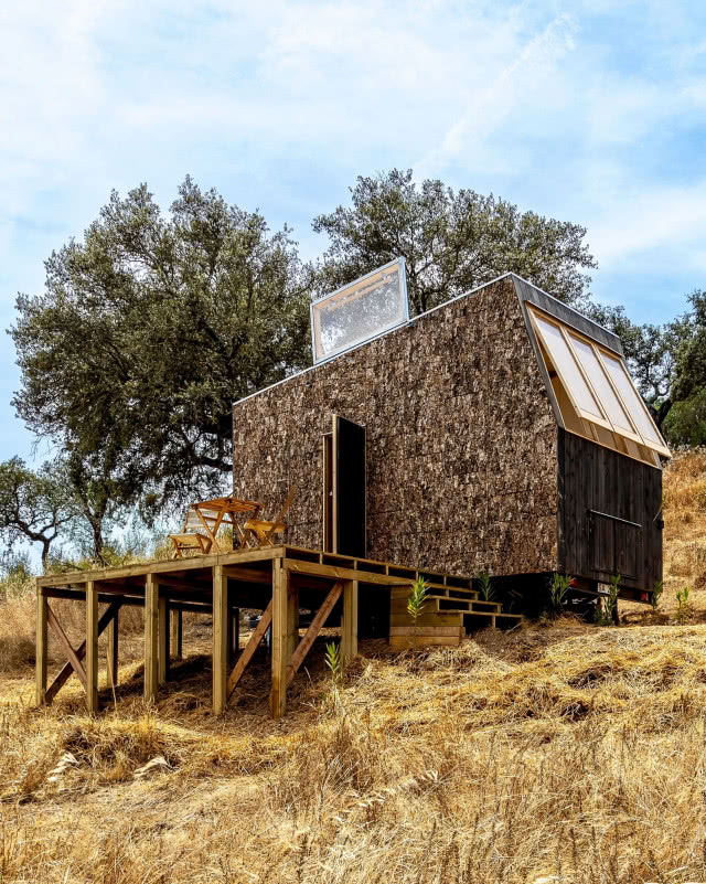 dom widziany z dołu, taras na palach i uchylne okno na dachu