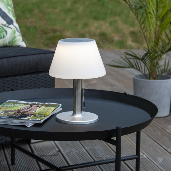 Designerska lampa solarna, która przypomina lampkę nocną w sypialni.