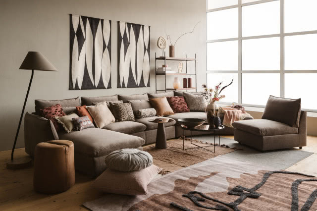 sofa modułowa, poduszki ozdobne, stolik kawowy, misa, wazony, obrazy, koce, półki, świece, dywan