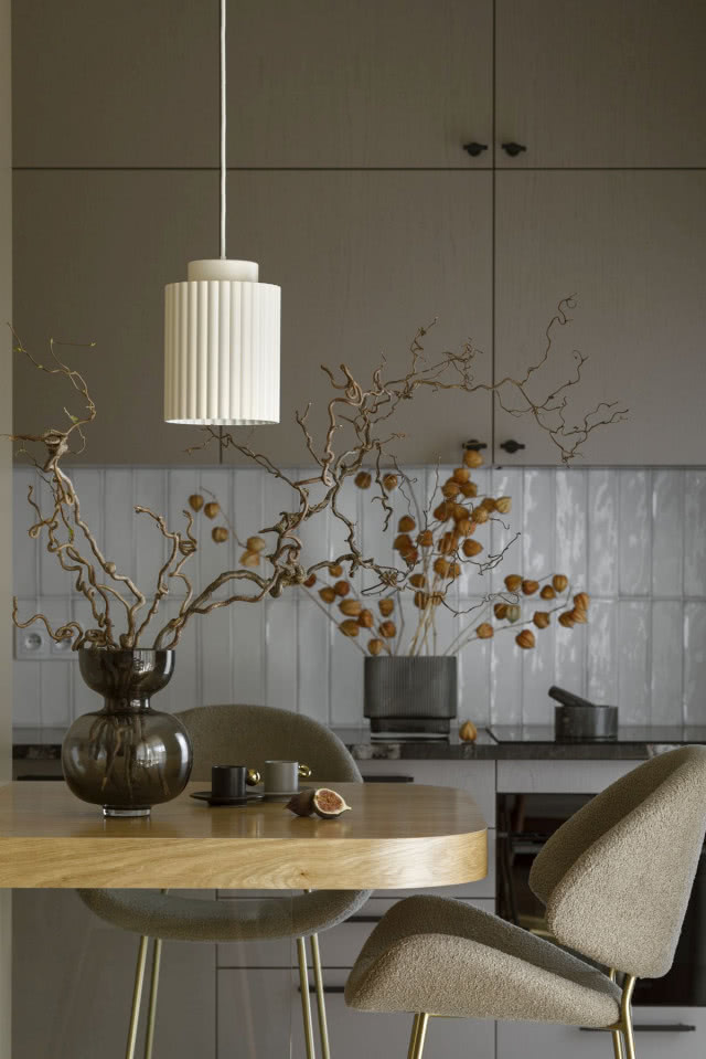 Strukturalne białe płytki nad kamiennym blatem w kuchni