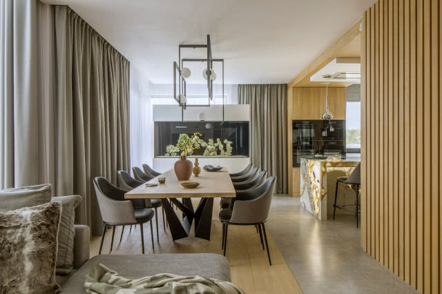 Stół jadalniany z szarymi krzesłami, nad nim oświetlenie