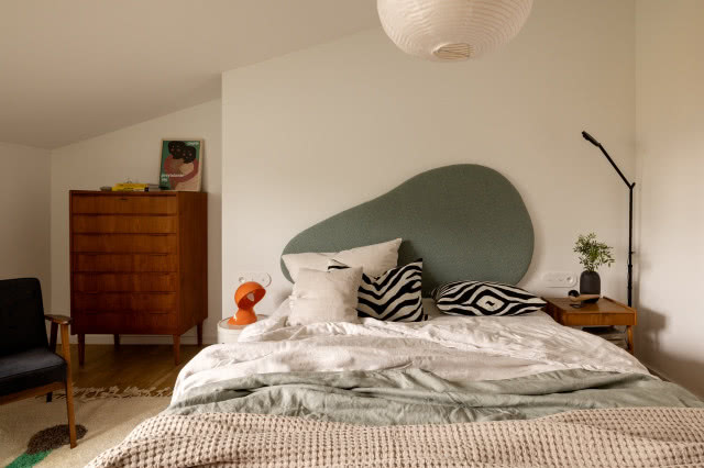 Łóżko w szałwiowym kolorze z zagłówkiem o nieregularnych kształtach