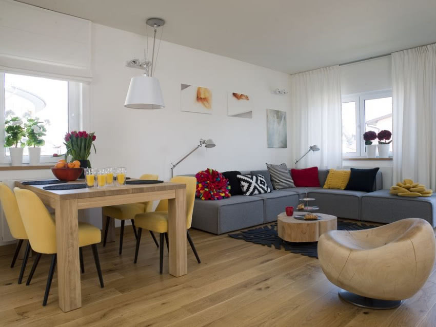 Na szarej kanapie kolekcja barwnych poduszek