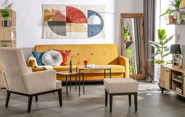 żólta wersalka, fotele, duże lustro, stołek, stoliki kawowe, komoda, półki kwiaty, lampa podłogowa