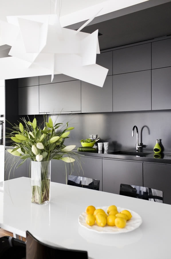 Matowa, szara zabudowa kuchenna kontrastuje z...