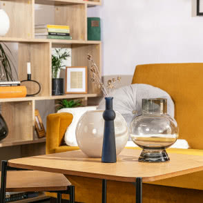 żólta wersalka, fotele, duże lustro, stołek, stoliki kawowe, komoda, półki kwiaty, lampa podłogowa