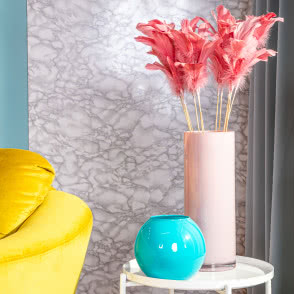 niebieski fotel, żółty fotel, lampa podłogowa biała, stoliki kawowe, wazony, lustro, różowa ściana, drewniana podłoga