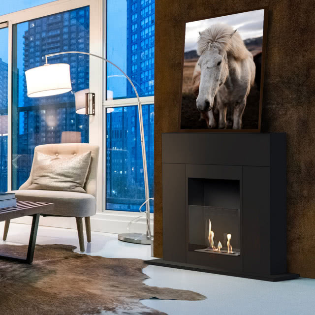 biokominek, fotel, stolik kawowy, skóra na podłodze, obraz z koniem, lampa podłogowa, duże okno