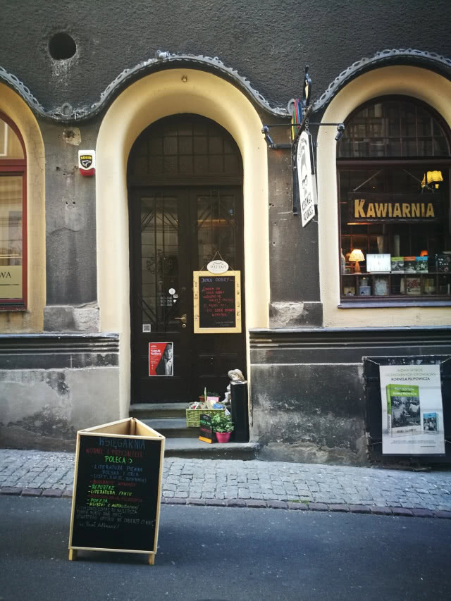 półokrągłe wejście do kamienicy z księgarnią