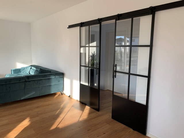 drzwi przesuwne, kanapa, drewniana podłoga