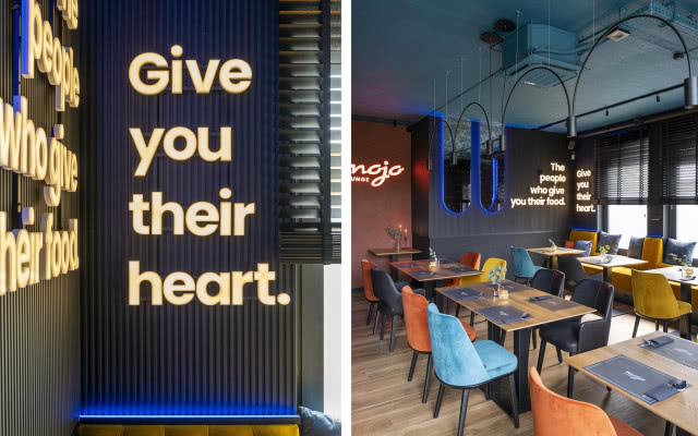 neon na ścianie i kolorowe krzesła w restauracji