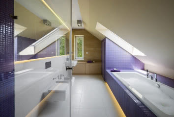 Ściany schowka w łazience wykończono fioletową mozaiką