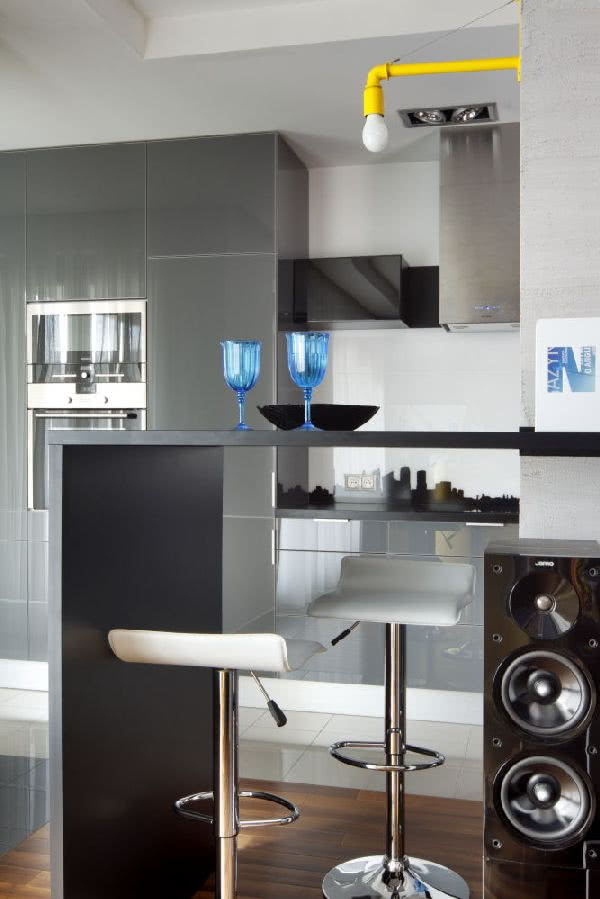 Grafitowy barek odcina się na tle szarej...