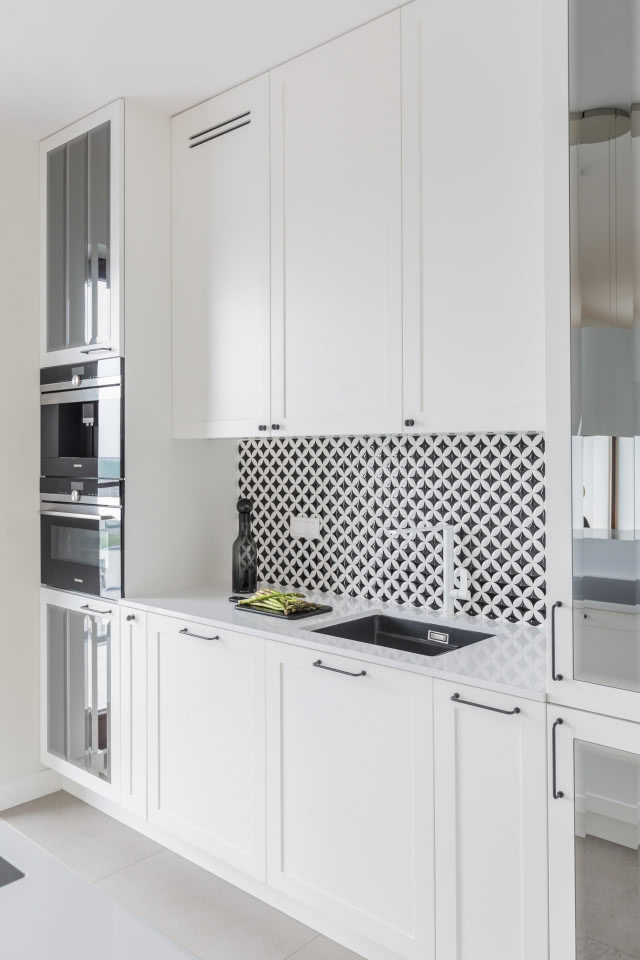 biała kuchnia z mozaiką nad blatem