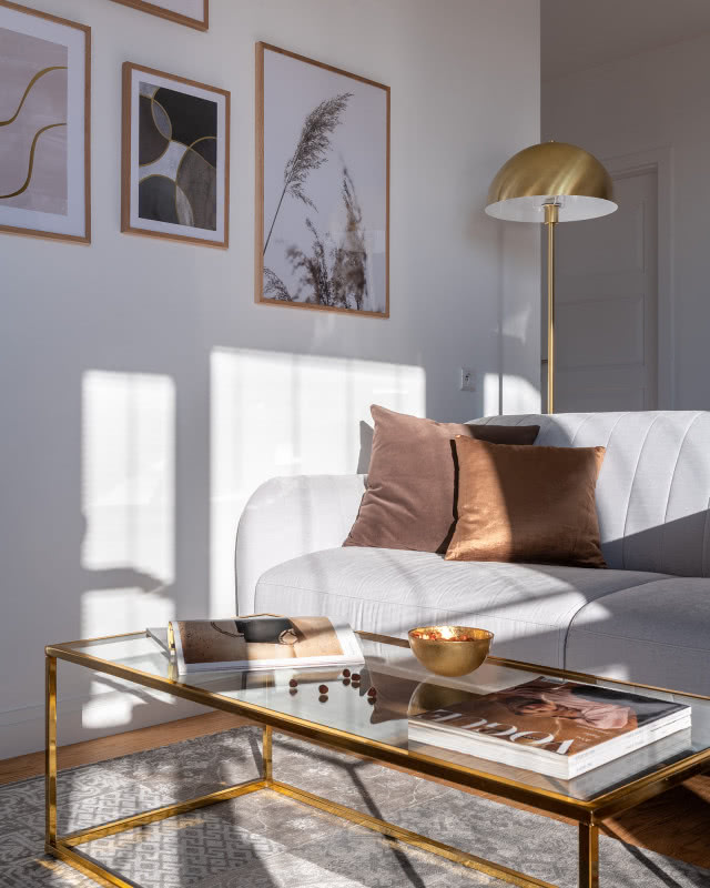 Złota lampa stojąca za sofą w salonie