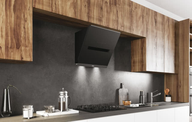 czarny okap, drewniane fronty kuchenne, płyta gazowa, kawiarka, cukier, deska do krojenia, beton na ścianie, zlewozmywak, bateria, wazon