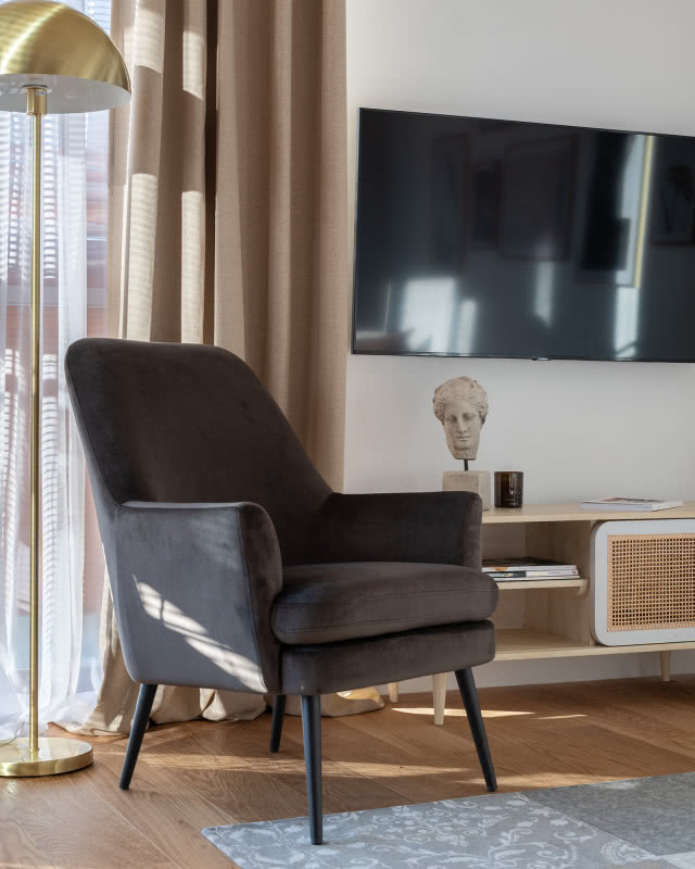 Szary fotel obity welurową tkaniną