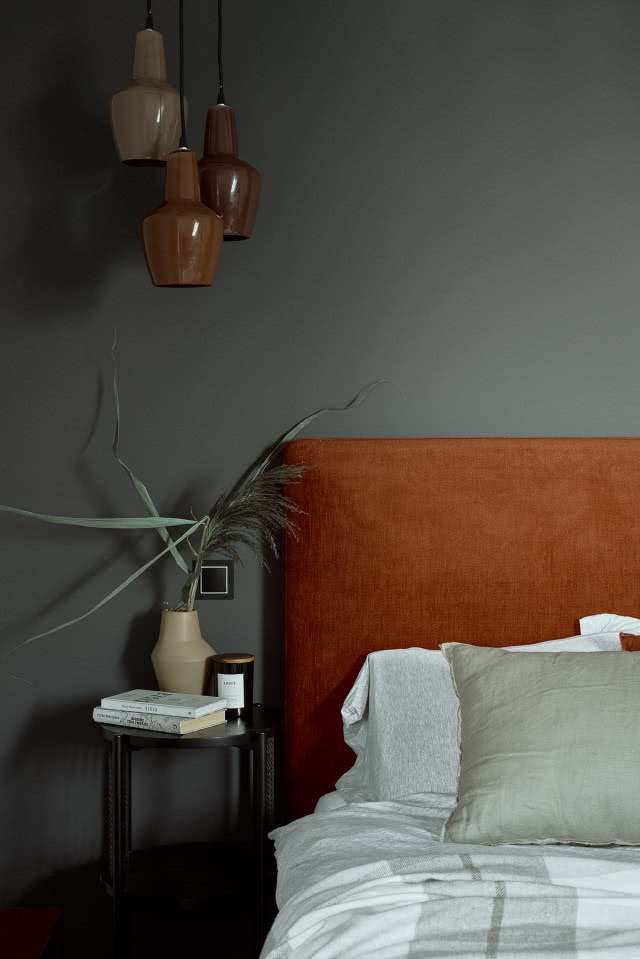 Sypialnia z szarymi ścianami i rudym łóżkiem
