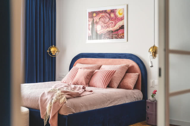 granatowe łóżko w sypialni