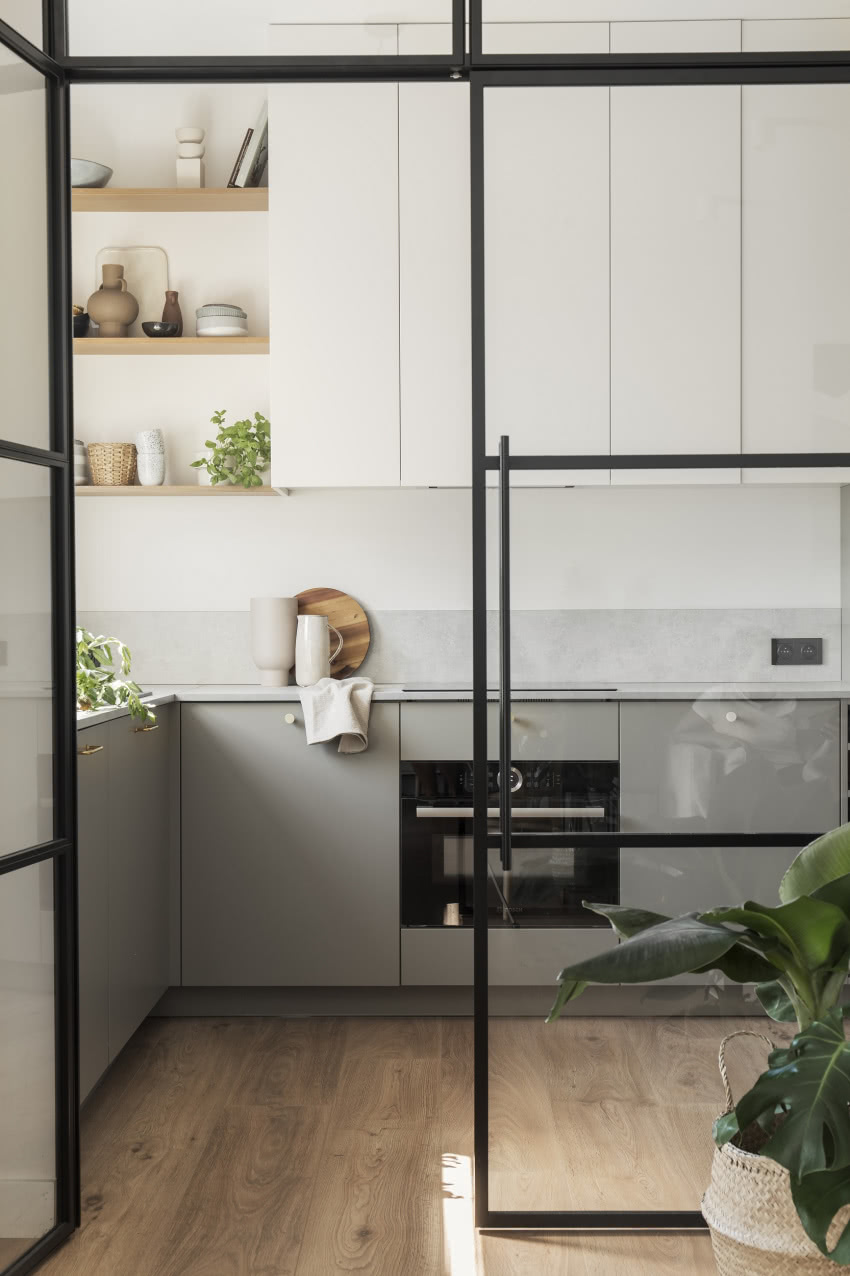 Poprzez szklaną ścianę widać
kuchnię z salonu,...