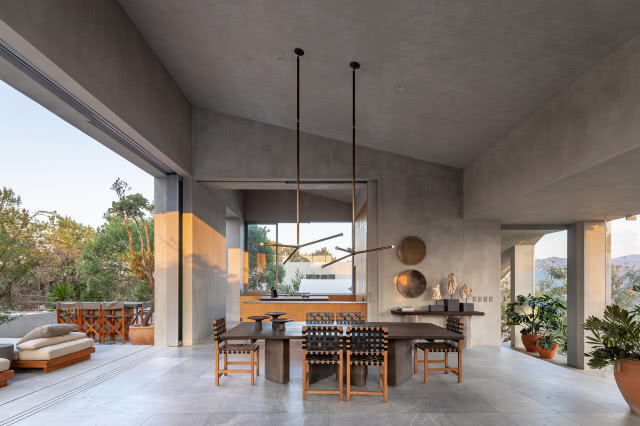 stół z dwiema wiszącymi lampami, nad konsolą okrągłe dekoracje z metalu