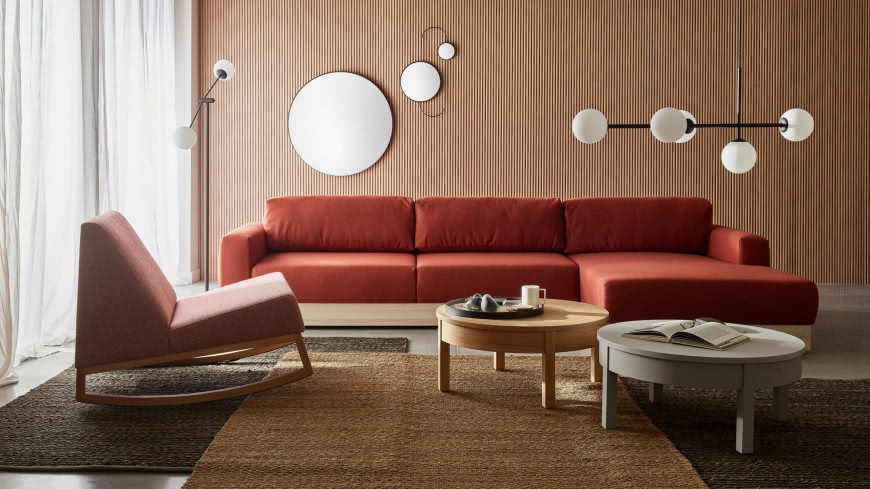 kanapa, fotel, stoliki kawowe, okrągłe lustra na ścianie. lamele na ścianie, lampa sufitowa, lampa podłogowa, dywany, firany