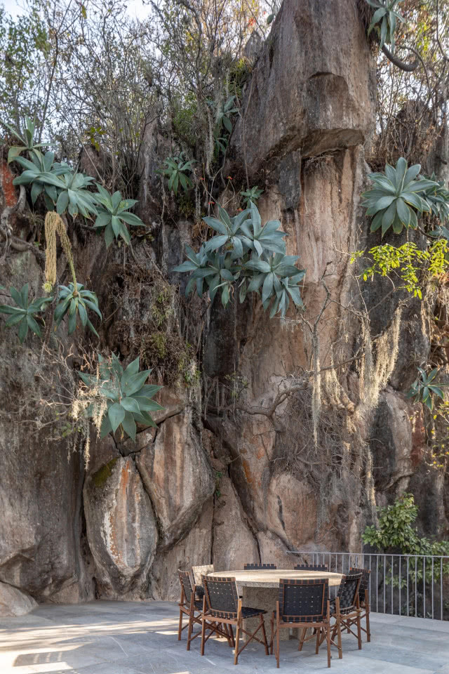 skała z roślinami, przy niej stół