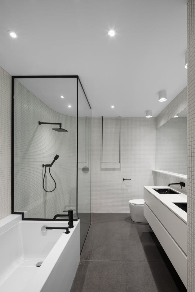 Jasna, minimalistyczna łazienka z prysznicem.