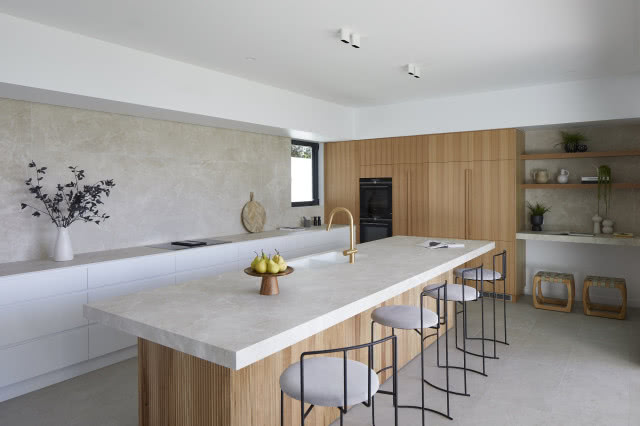 Drewniane meble z dużą wyspą kuchenną