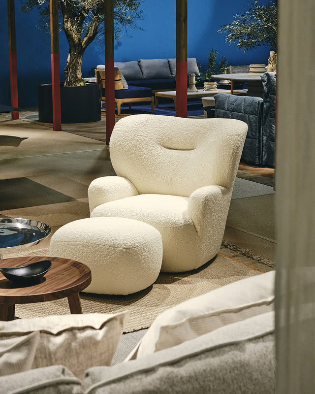 obły biały fotel z podnóżkiem