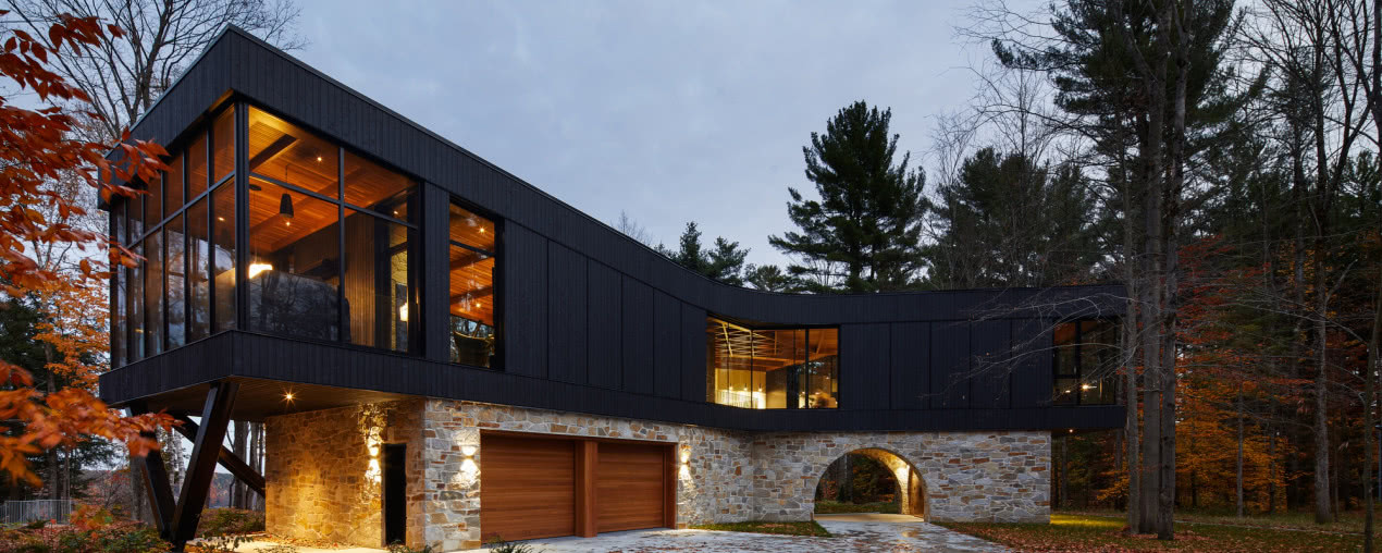 Czarny dom w kształcie litery Y! Dominuje w nim kamień i drewno