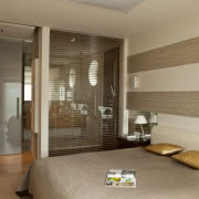 Za szklaną ścianą sypialni jest prysznic.