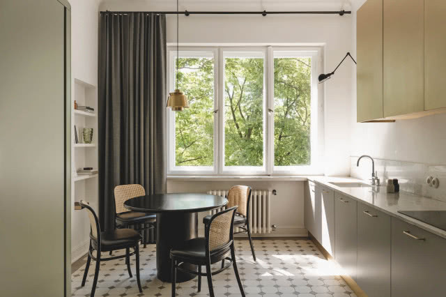 Kuchnia w mieszkaniu w kamienicy - podłoga oryginalna, czarny okrągły stół