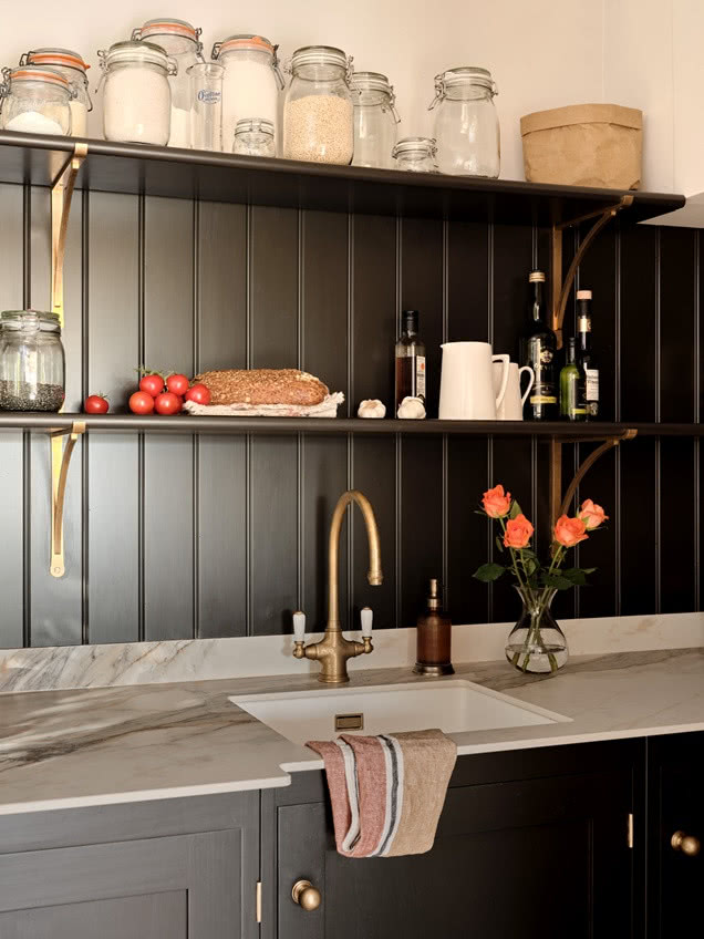 otwarte półki na tle ciemnej boazerii