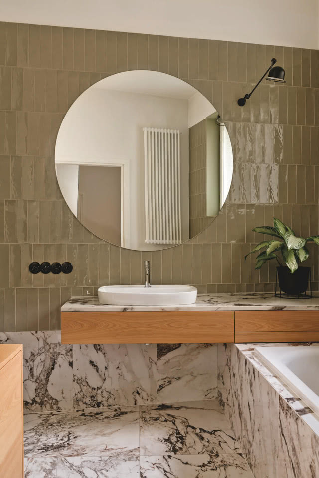 łazienka - zielone płytki podłużne i ciekawa okładzina wanny