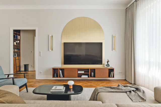 ciekawa wnęka na telewizor w salonie - okładzina z mosiądzu