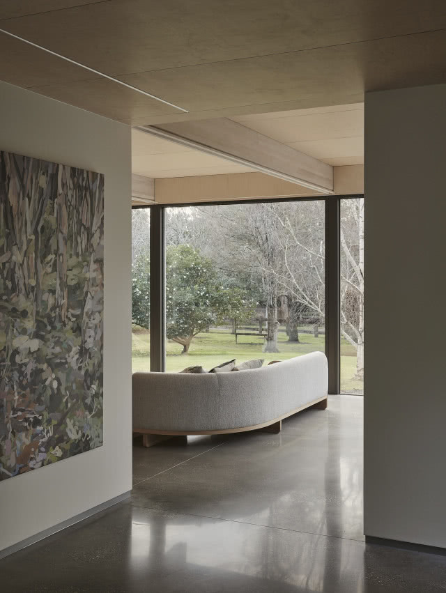 Ciekawa w formie sofa z drewnianą ramą i półokrągłym oparciem.