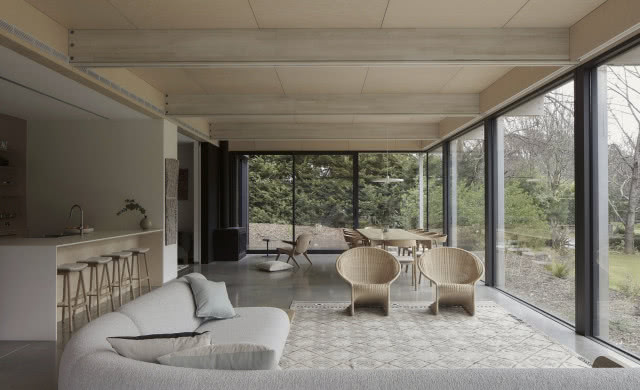 Widok na kuchnię, stół i czarną kozę.