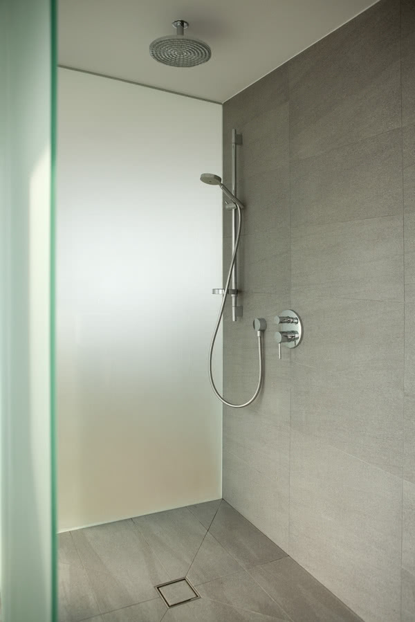 Prysznic w minimalistycznej łazience na górze.