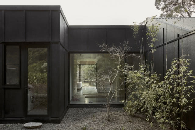 Łącznik między starym budynkiem a nowym pawilonem. Obie części zostały pokryte czarną sklejką.