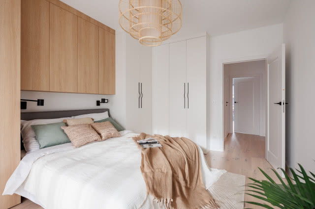 sypialnia w stonowanych kolorach z drewnianą zabudową