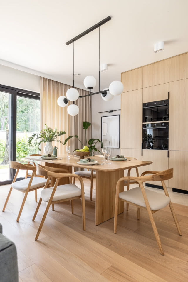 Drewniana podłoga, stół i zabudowa kuchenna