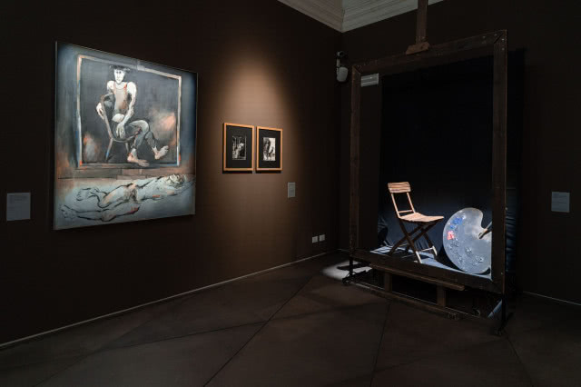 Fragment wystawy Tadeusza Kantora: obraz, grafiki oraz instalacja z krzesłem i paletą malarską w ciemnej przestrzeni galerii.