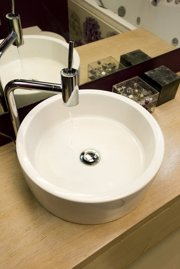 Okrągła umywalka nablatowa kształtem przypomina...