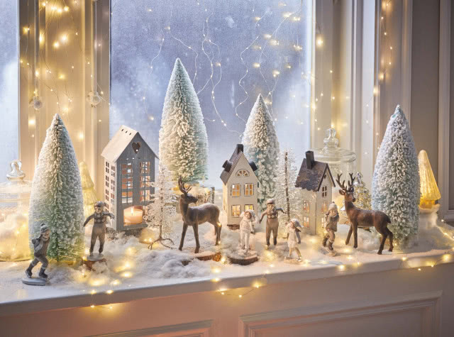 ozdoby świąteczne, choinki, figurki dzieci i jeleni, sztuczny śnieg, lampki na oknie