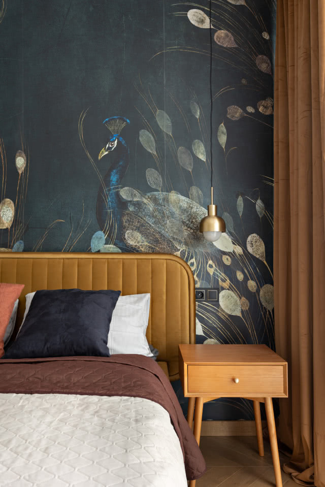 Wzorzysta tapeta w pawie z musztardowym zagłówkiem łóżka